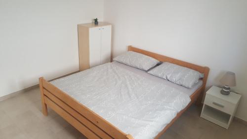 a bedroom with a wooden bed with two pillows at Vila Maria Nin in Nin