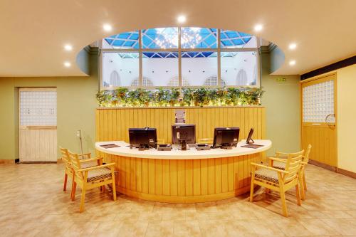 a waiting room with a round counter with chairs at E Square The Fern, Pune in Pune