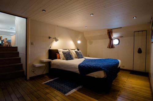 a bedroom with a bed with a blue blanket at Houseboat Jana - with sauna and terrace in Bruges