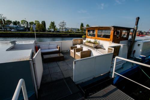 Houseboat Jana - with sauna and terrace في بروج: قارب يرسي في الماء