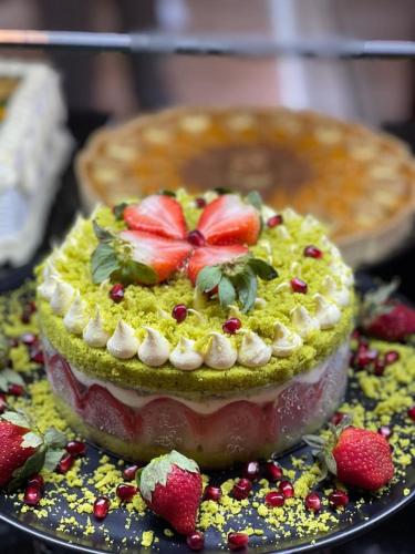 a dessert with strawberries on top on a plate at Dedeman Erbil Hotel City Center in Erbil