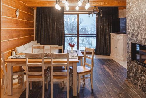 a dining room with a table and chairs and a couch at TatrApart in Zakopane