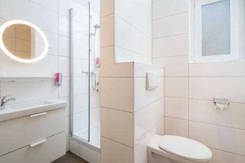 a white bathroom with a toilet and a sink at Stadt-gut-Hotel Rheinischer Hof in Essen