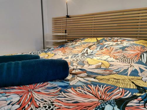 ein Bett mit einer bunten Decke darüber in der Unterkunft COC - Le Phare in Wissant