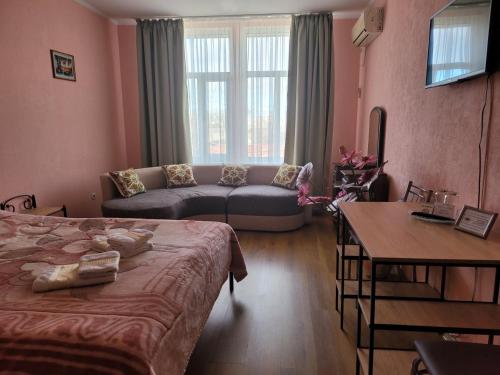 a room with a bed and a couch and a table at Vodnyi Mir in Bilhorod-Dnistrovsʼkyy