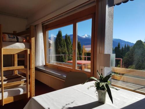 Habitación con mesa y ventana con vistas a la montaña. en Casa Crap en Trin