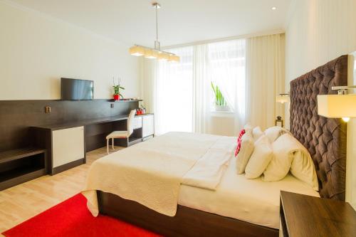 a bedroom with a bed with a desk and a red rug at Hotel Bonsai in Mikulov