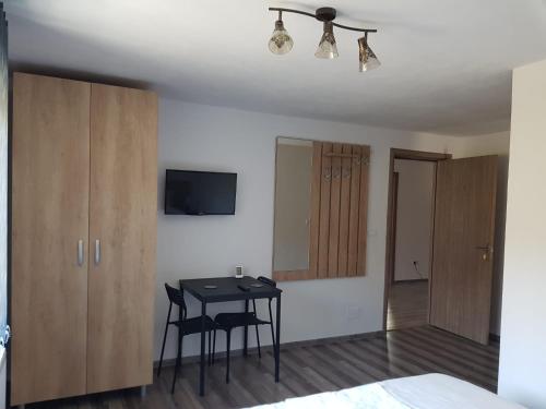 a room with a table and cabinets and a bedroom at Viata la Tara Cerna in Cerna