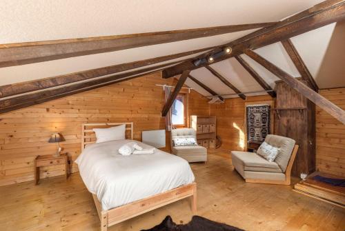 1 dormitorio con 1 cama y 2 sillas en una habitación en Chalet Noisette Authentic Swiss chalet Perfect for families, en Riddes