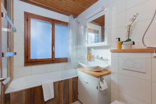 baño con lavabo y ventana en Chalet Noisette Authentic Swiss chalet Perfect for families, en Riddes