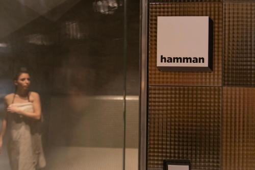 a woman is standing next to a sign on a elevator at ibis Styles Zeebrugge in Zeebrugge