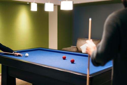 a person playing pool with two balls on a pool table at City Hotel Thessaloniki in Thessaloniki