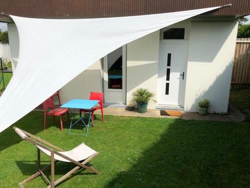 ein Zelt über einem Tisch und Stühlen im Hof in der Unterkunft L'orée du Golf, studio 4 in Mont-Saint-Aignan