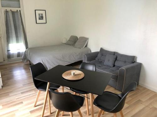 un salon avec un canapé, une table et des chaises dans l'établissement L'orée du Golf, studio 4, à Mont-Saint-Aignan