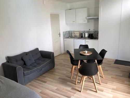 un salon avec un canapé, une table et des chaises dans l'établissement L'orée du Golf, studio 4, à Mont-Saint-Aignan