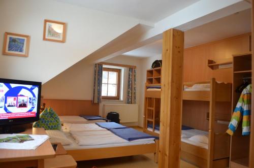 a room with three bunk beds and a tv at Apartment Mauser-Mühltaler in Mauterndorf