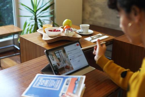 a woman sitting at a table with a laptop at Hotel Santa Clara in Santiago de Compostela