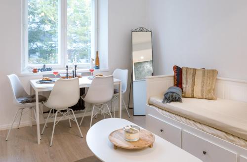 Habitación con cama, mesa y sillas. en Kotoisa & Tyylikäs Keskusta-asunto Neljälle!, en Tampere
