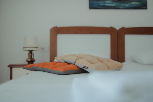 a bed with two pillows on top of it at Nonna's Boutique Hotel in Dhërmi