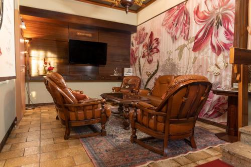 a living room with two chairs and a flat screen tv at Hotel Schlair in Kremsmünster