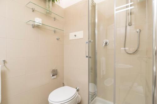 W łazience znajduje się toaleta i przeszklony prysznic. w obiekcie Contempora Apartments - Elvezia 8 - E54 w Mediolanie