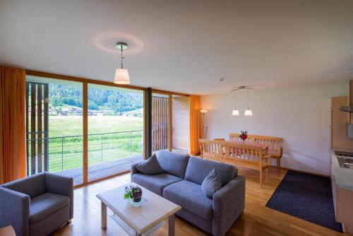 ein Wohnzimmer mit einem Sofa und einem Tisch sowie ein Esszimmer in der Unterkunft Apartments Susanne in Au im Bregenzerwald