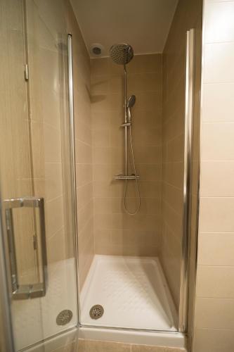 a shower with a glass door in a bathroom at Hostal Martínez in Villafranca
