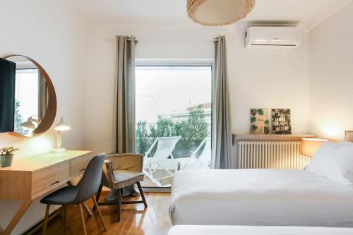 a hotel room with a bed and a desk and a window at Acropolis Veranda Residence in Athens
