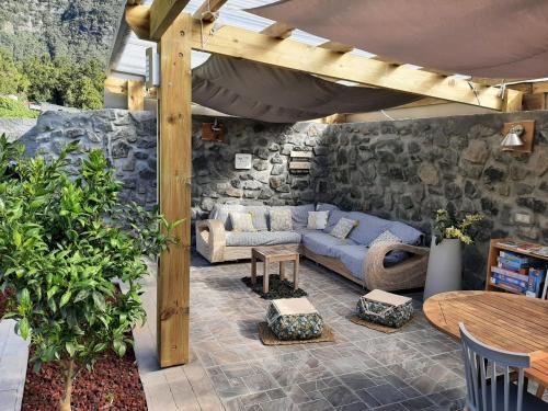 a patio with a blue couch and a stone wall at La Croisee des Sentiers in Salazie