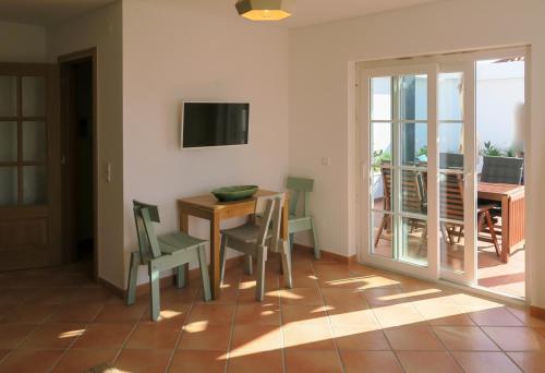 a dining room with a table and chairs and a television at Cabanas de Tavira in Cabanas de Tavira