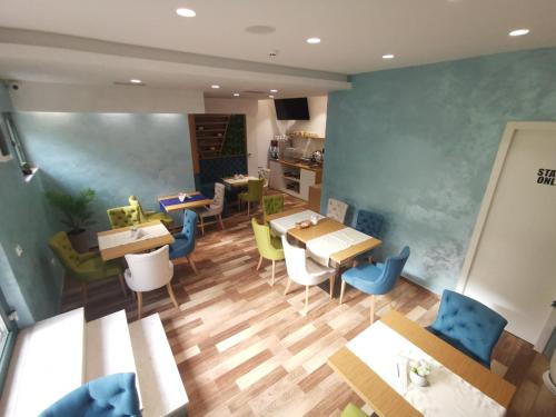 ein Esszimmer mit Tischen und Stühlen und eine Küche in der Unterkunft Hotel Alkima in Kotor