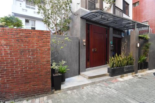 a brick building with a red door and a brick wall at Fu's house 52 in Tainan