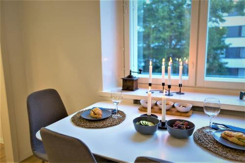 - une table avec des assiettes de nourriture et des bougies dans l'établissement Viihtyisä & Varusteltu Keskusta-asunto Neljälle!, à Tampere