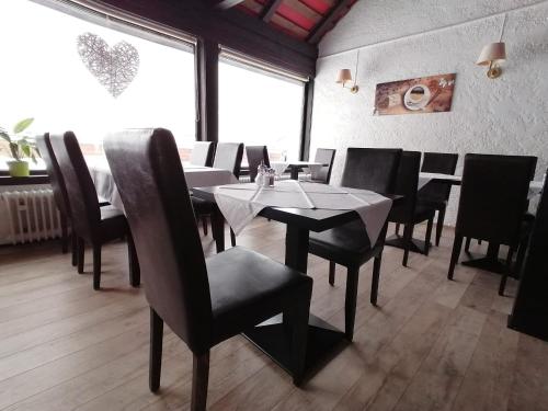 a dining room with tables and chairs in a restaurant at Hotel Skandinavia in Sankt Andreasberg