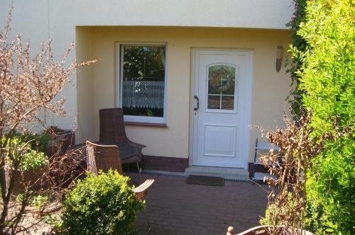 a white door on a house with a patio at Gästehaus Schmidt in Boltenhagen