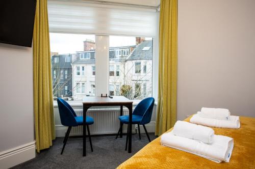a room with a table and chairs and a window at Stay Coastal in Whitley Bay