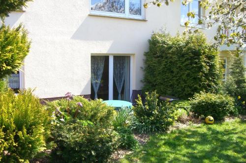a white house with a table in a garden at Gästehaus Schmidt in Boltenhagen