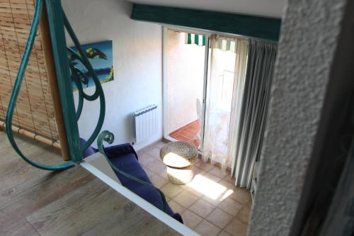 une chambre avec deux chaises bleues et un balcon dans l'établissement De la couleur aux Marquises, à La Londe-les-Maures