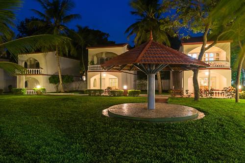 a large house with a large umbrella in the yard at Ideal Beach Resort in Mahabalipuram