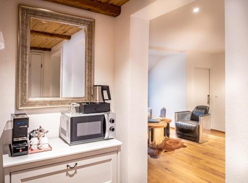 a kitchen with a microwave and a mirror on the wall at Mäsers Allgäuherz in Wiggensbach