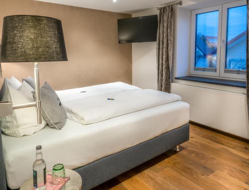 a bedroom with a bed with a lamp and a window at Mäsers Allgäuherz in Wiggensbach