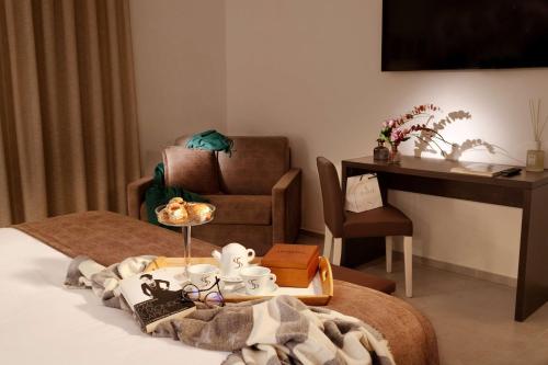 a room with a bed with a table and a desk at San Severino Park Hotel & SPA, BW Signature Collection in Mercato San Severino