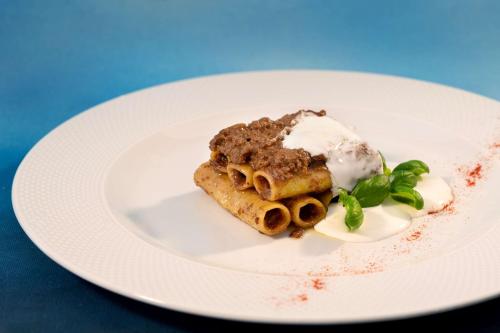 a white plate with a piece of food on it at San Severino Park Hotel & SPA, BW Signature Collection in Mercato San Severino