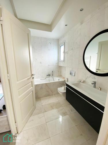 a bathroom with a tub and a toilet and a sink at Le Safran - apt renove, spacieux et central a Marsa in Carthage