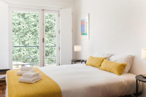 a white bedroom with a large bed with towels on it at VIVA Casa da Vila River & Sea in Porto-Family & Friends in Porto
