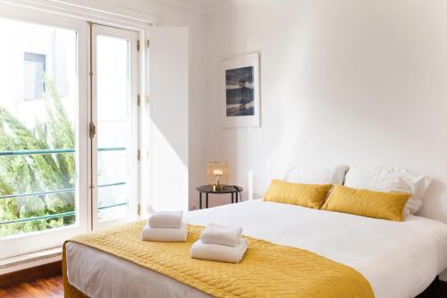 a white bedroom with a large bed with two towels on it at VIVA Casa da Vila River & Sea in Porto-Family & Friends in Porto