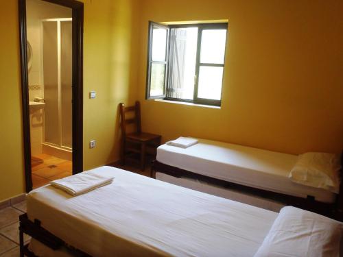 2 camas en una habitación con espejo y ventana en Albergue Las Almunias, en Las Almunias