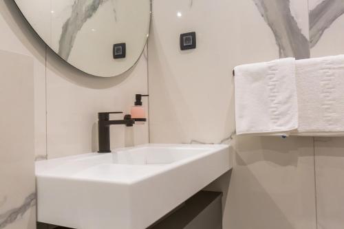 La salle de bains blanche est pourvue d'un lavabo et d'un miroir. dans l'établissement Villa Braga a5, à Baška Voda