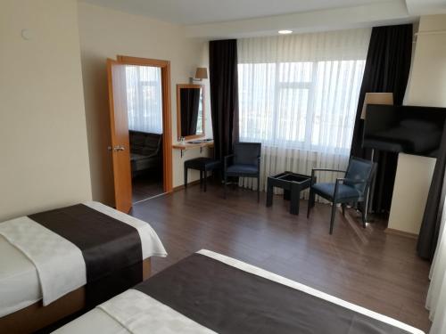 a hotel room with a bedroom with a bed and a desk at SİMİSSO HOTEL in Samsun