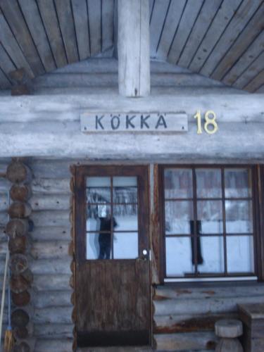 a door of a log cabin with a sign on it at Hakamajat Cottages in Syöte